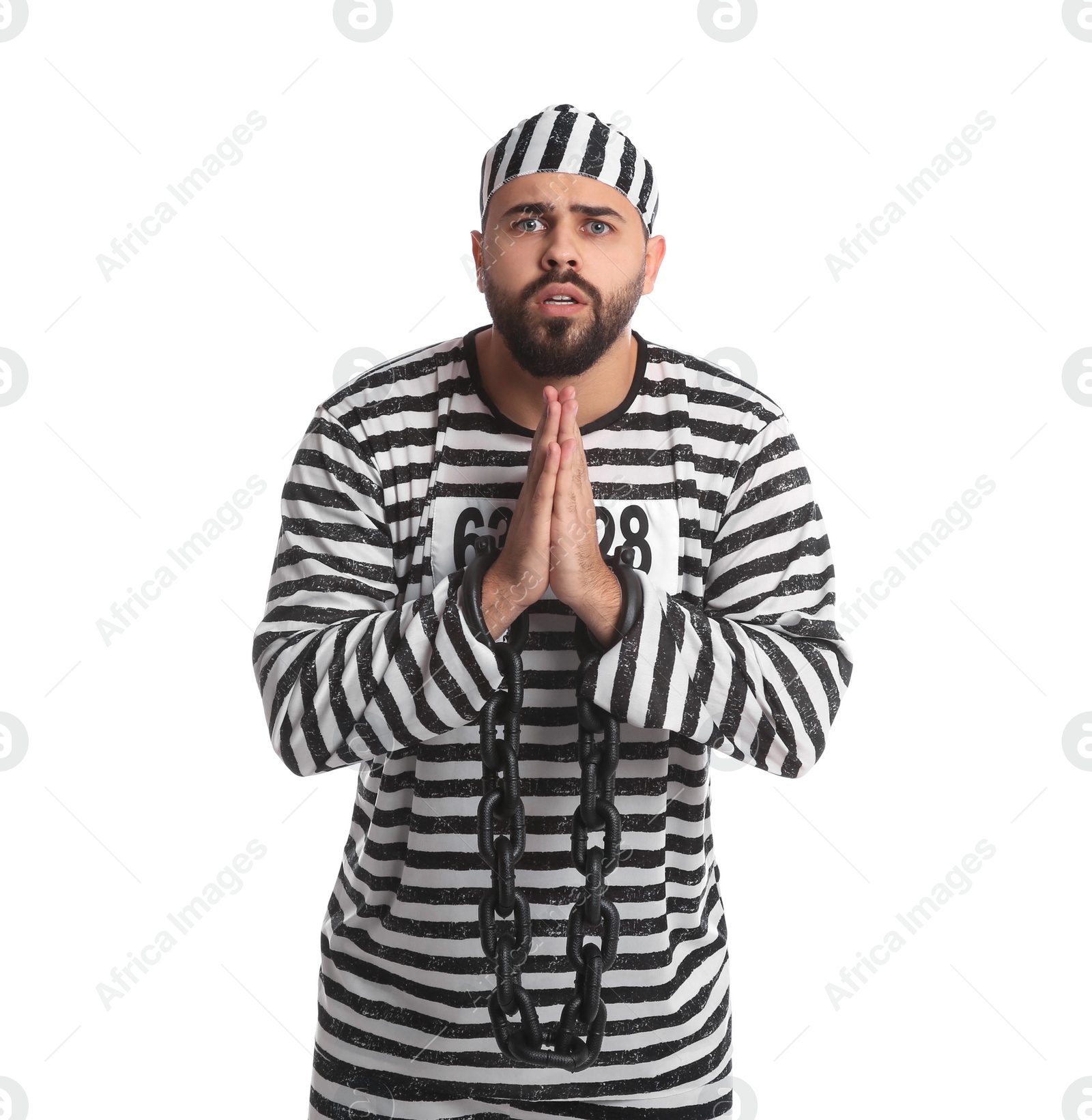 Photo of Prisoner in special uniform with chained hands praying on white background