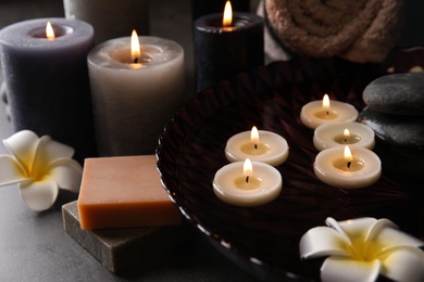 Photo of Spa composition with candles and cosmetic on table