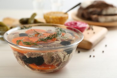 Photo of Delicious aspic with meat on white wooden table, closeup