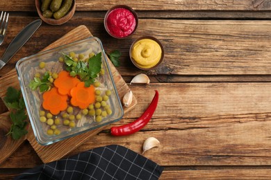 Photo of Delicious aspic with meat served on wooden table, flat lay. Space for text