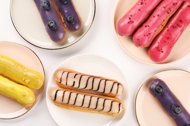 Photo of Delicious eclairs covered with glaze on white background, top view