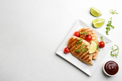 Tasty grilled chicken fillets with cherry tomatoes and lime slices on light grey table, flat lay. Space for text