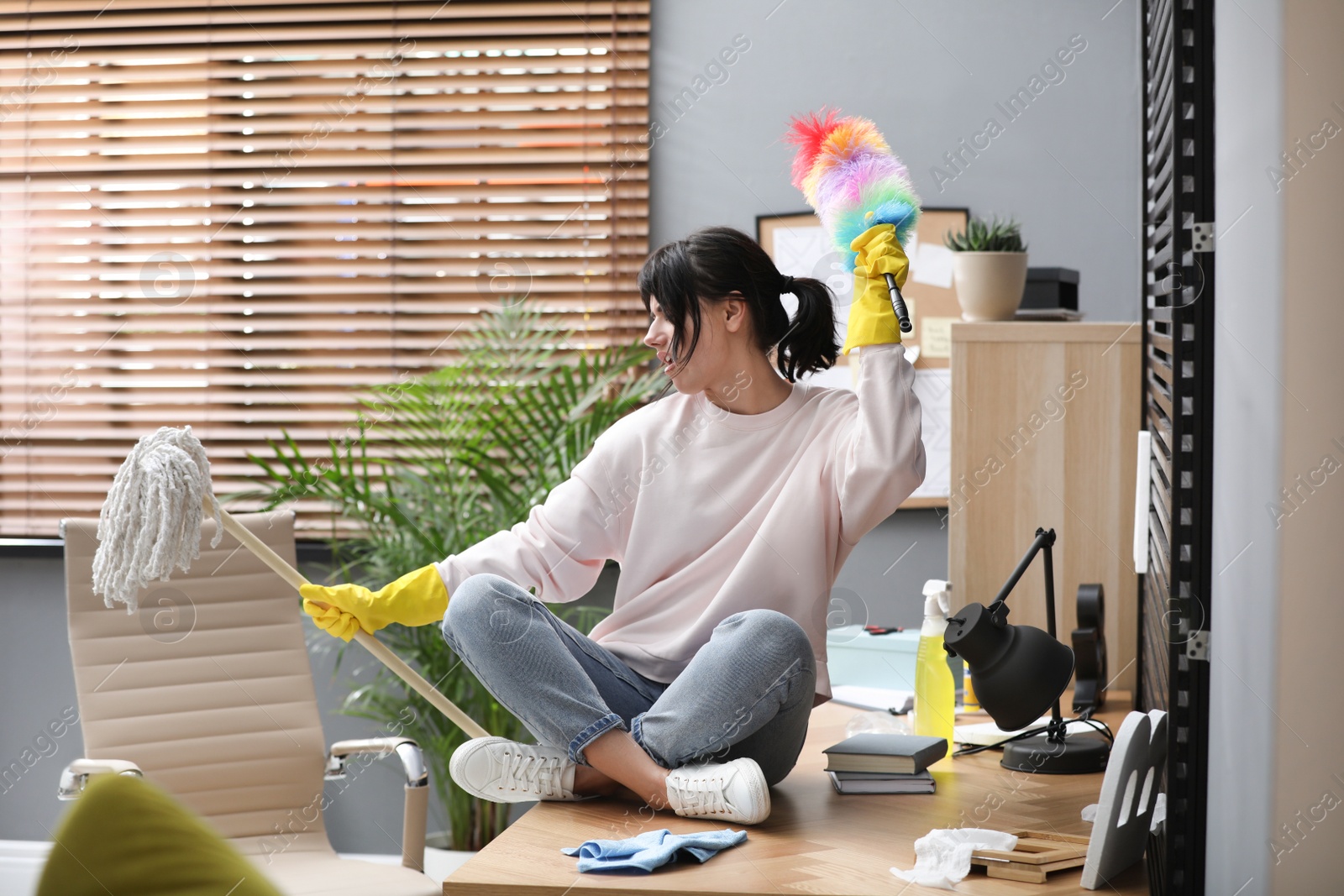 Photo of Lazy woman having fun while cleaning at home