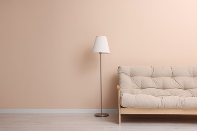 Photo of Comfortable sofa and stylish lamp indoors. Space for text