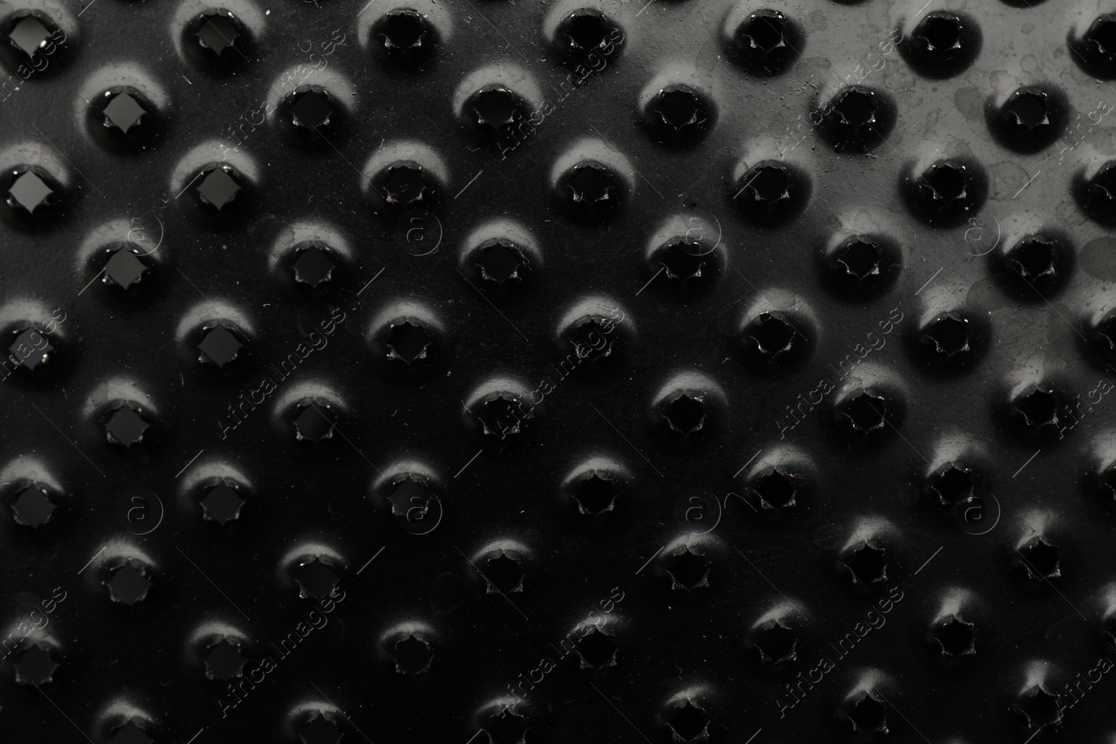 Photo of Modern black grater as background, top view