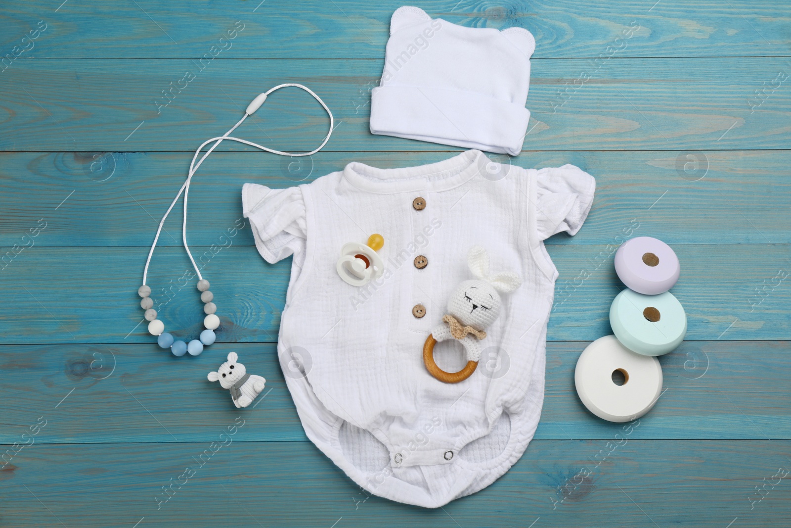 Photo of Flat lay composition with baby clothes and accessories on light blue wooden table