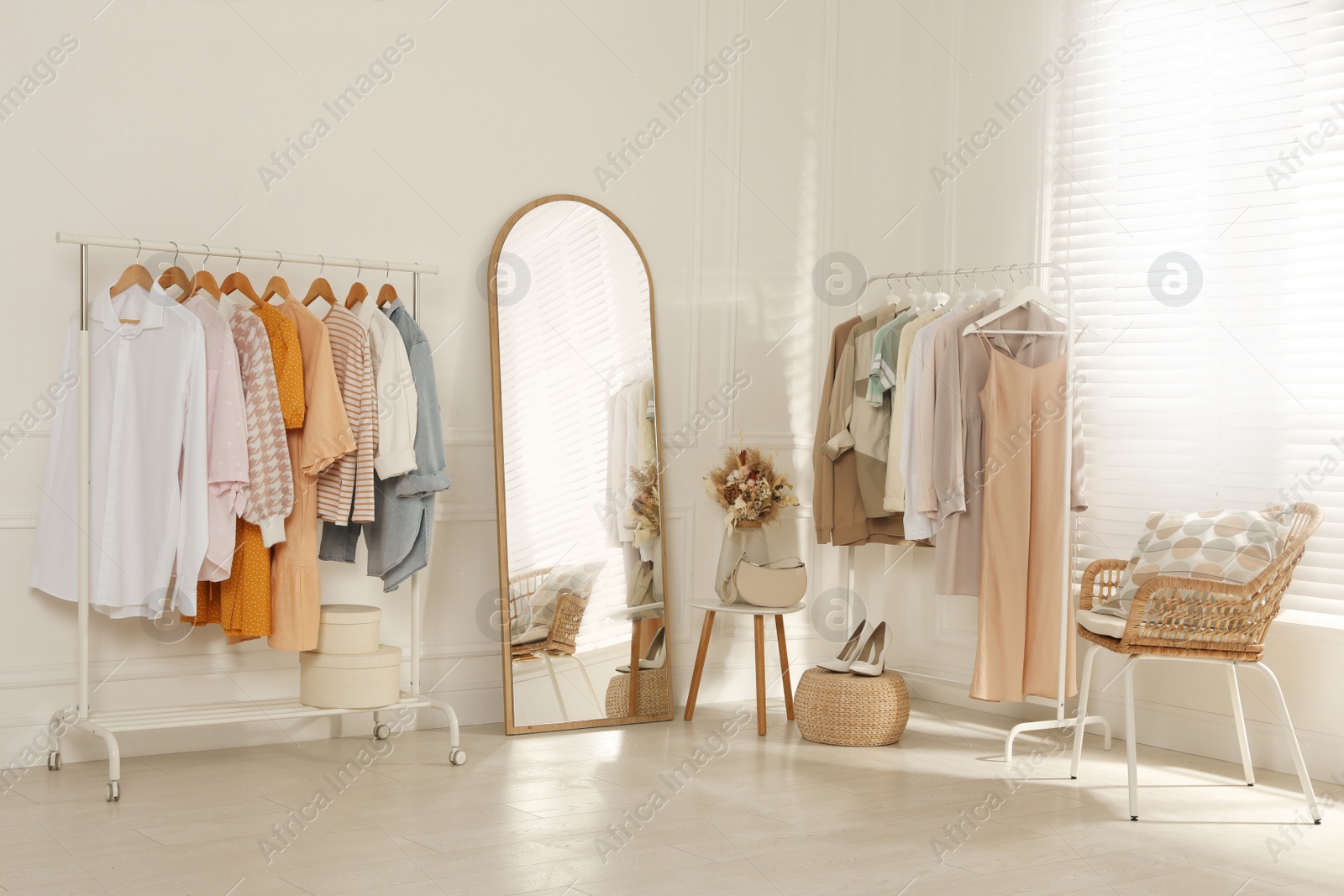 Photo of Modern dressing room interior with stylish clothes, shoes and beautiful dry flowers