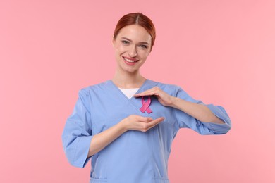 Photo of Mammologist with pink ribbon on color background. Breast cancer awareness