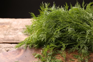 Photo of Fresh dill on wooden table, closeup. Space for text