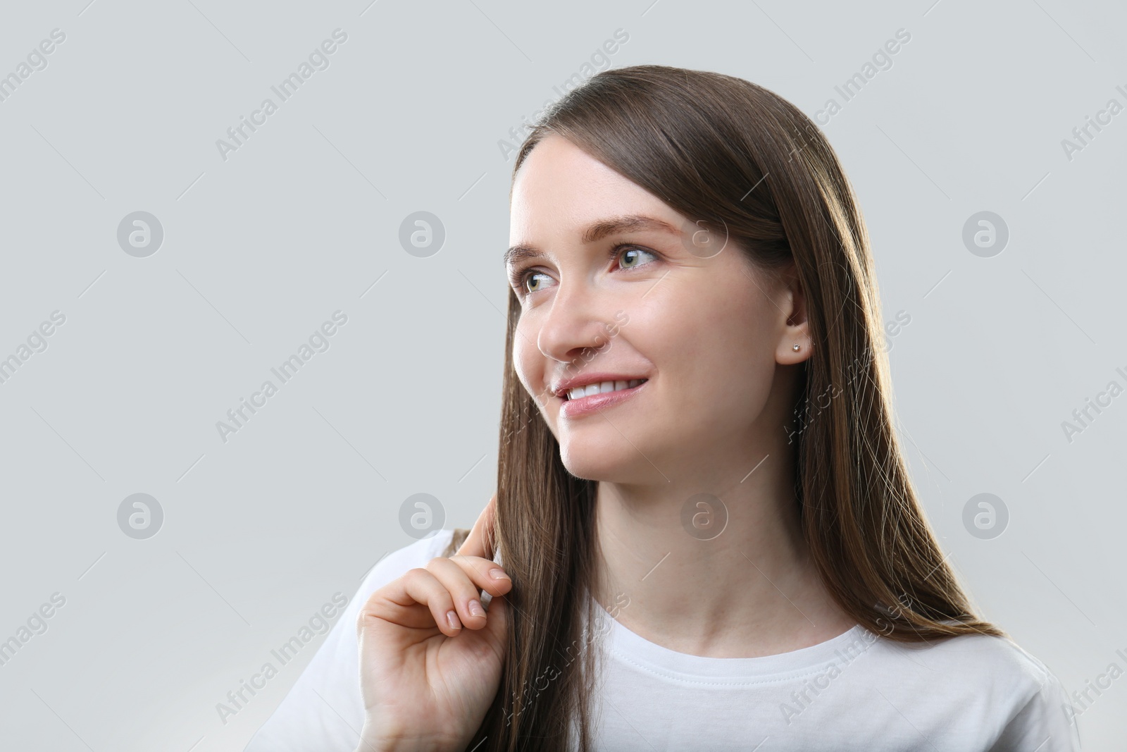 Photo of Portrait of beautiful happy woman on light grey background, space for text