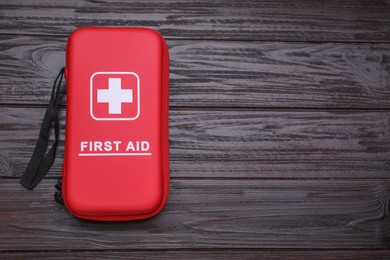 Photo of Medicine bag on wooden table, top view with space for text. First aid kit