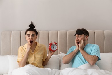 Photo of Emotional overslept couple in bed. Being late concept