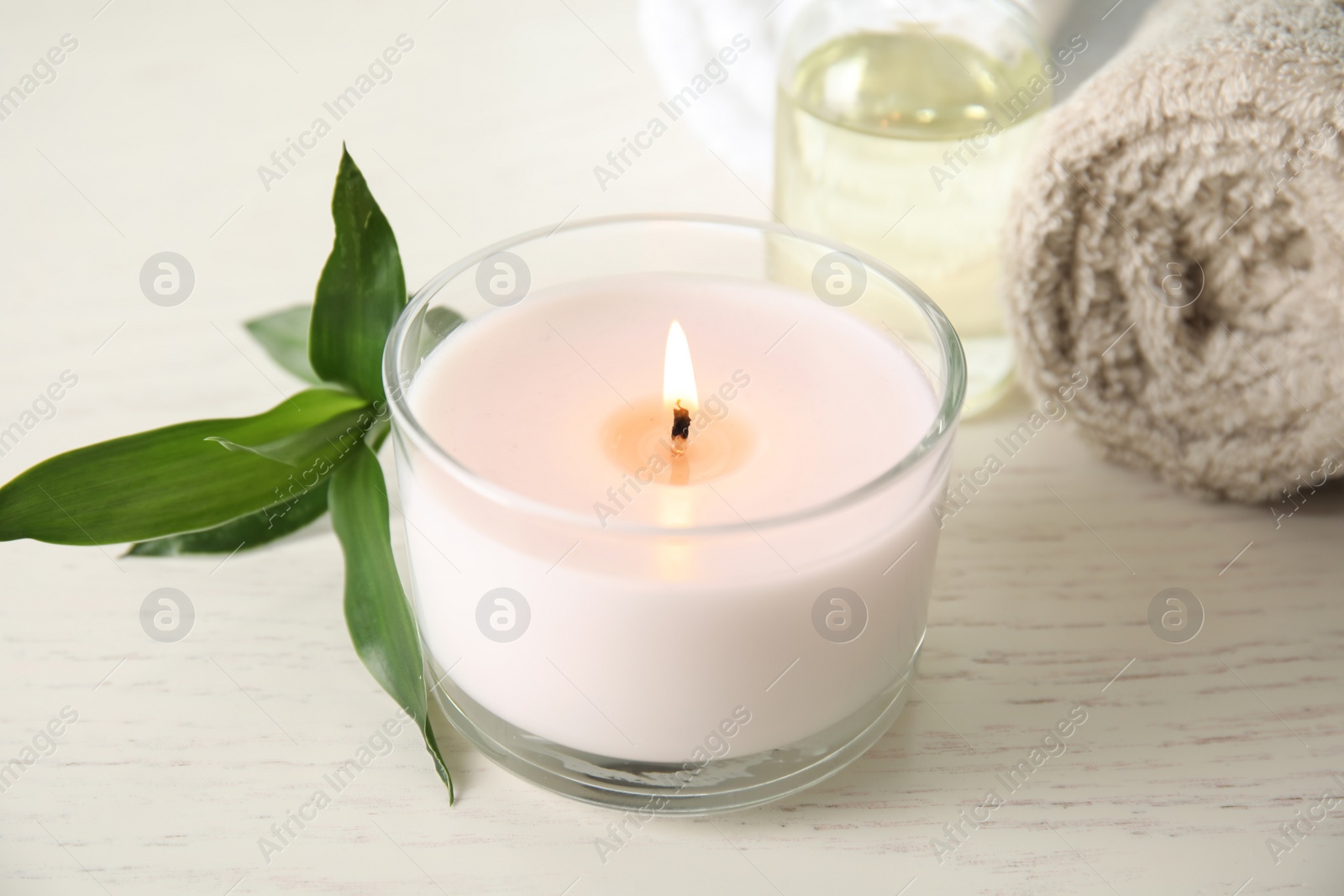 Photo of Spa composition with burning candle on table, closeup