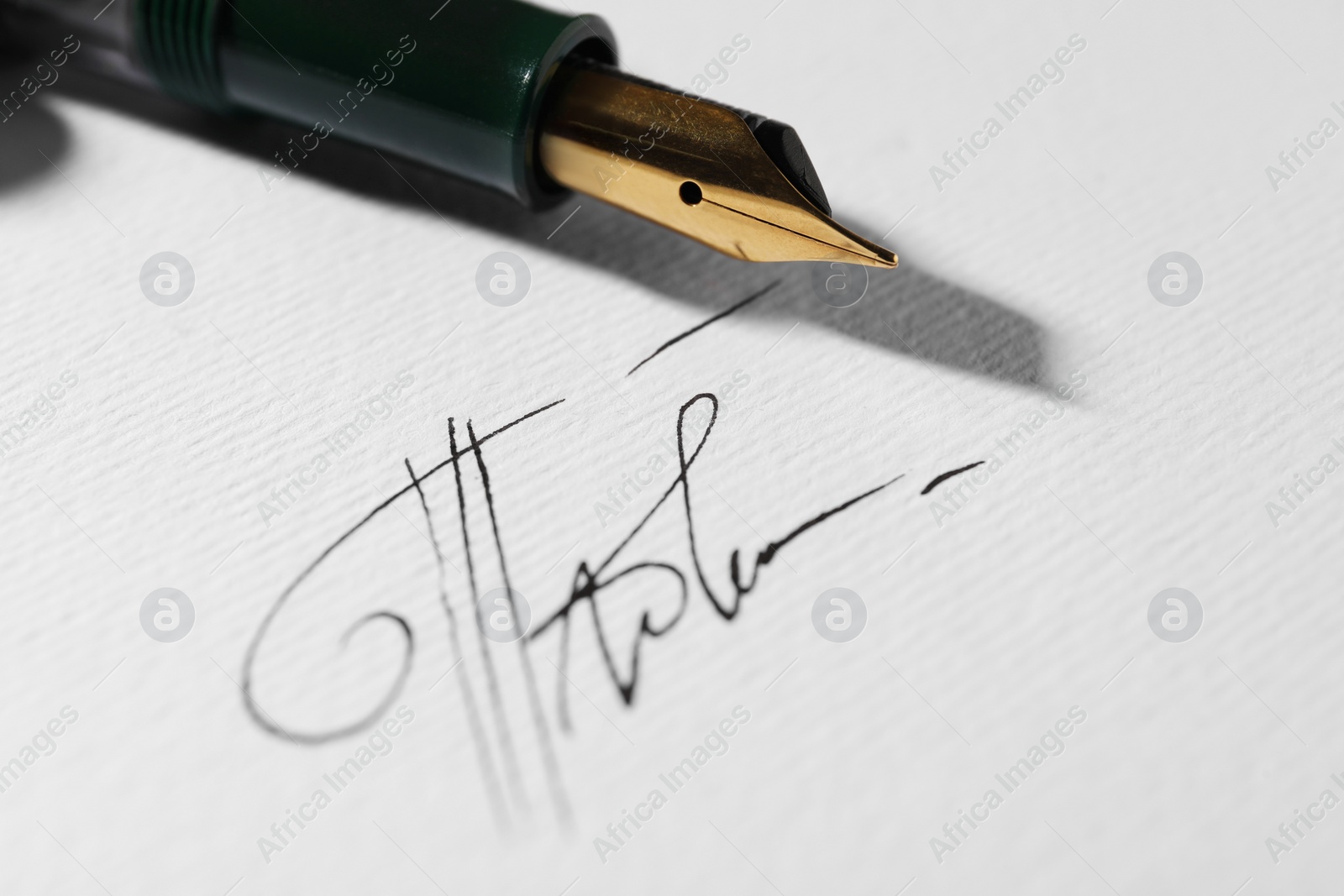 Photo of Sheet of paper with fountain pen and signature, closeup