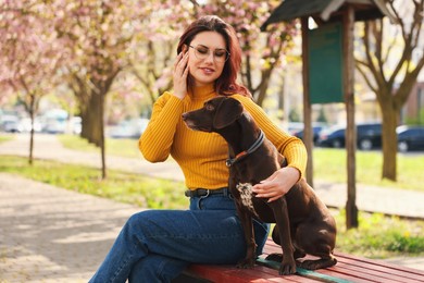 Woman with her cute German Shorthaired Pointer dog in park on spring day