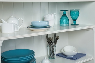 White shelving unit with set of dishware