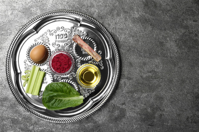 Photo of Passover Seder plate (keara) on grey table, top view with space for text. Pesah celebration