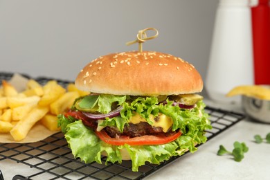 Photo of Delicious burger with beef patty and lettuce on white table, closeup