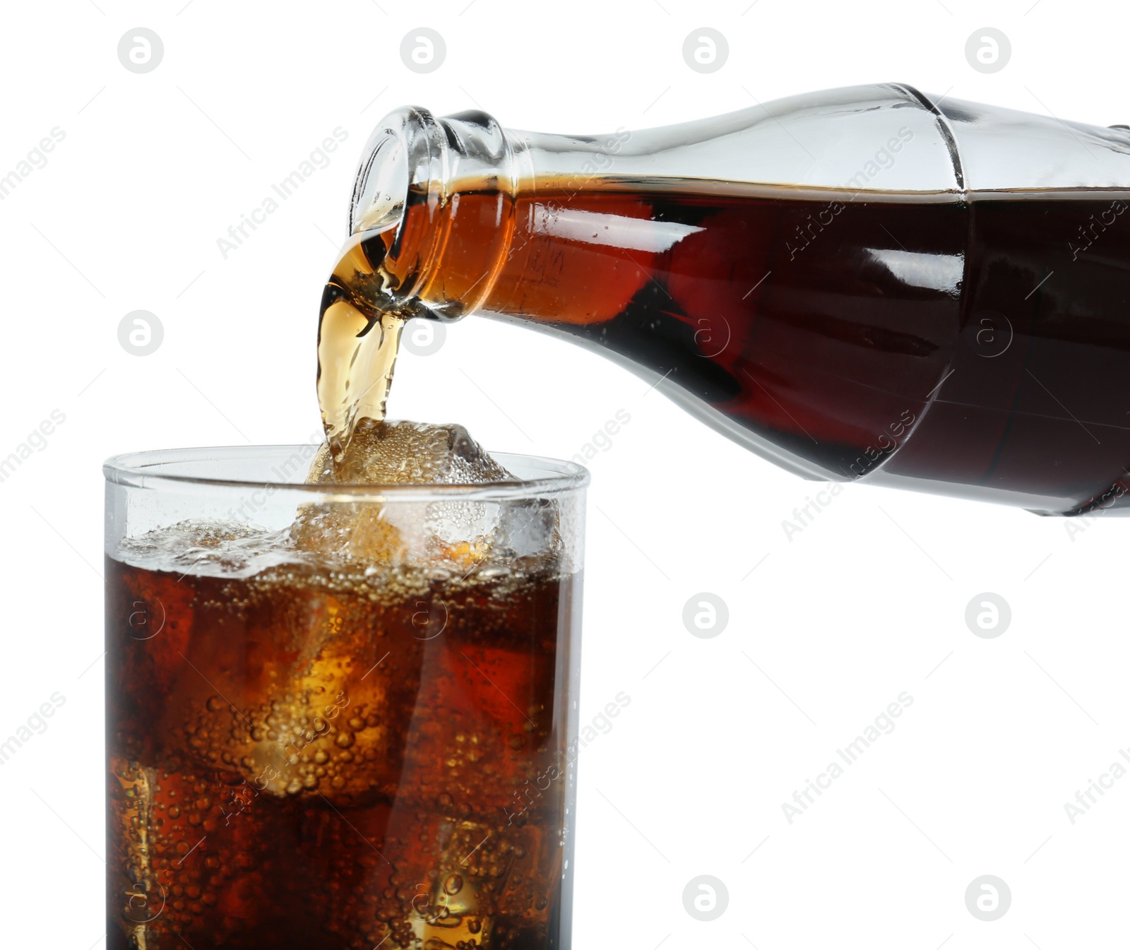 Photo of Pouring cola from bottle into glass with ice cubes on white background, closeup. Refreshing soda water