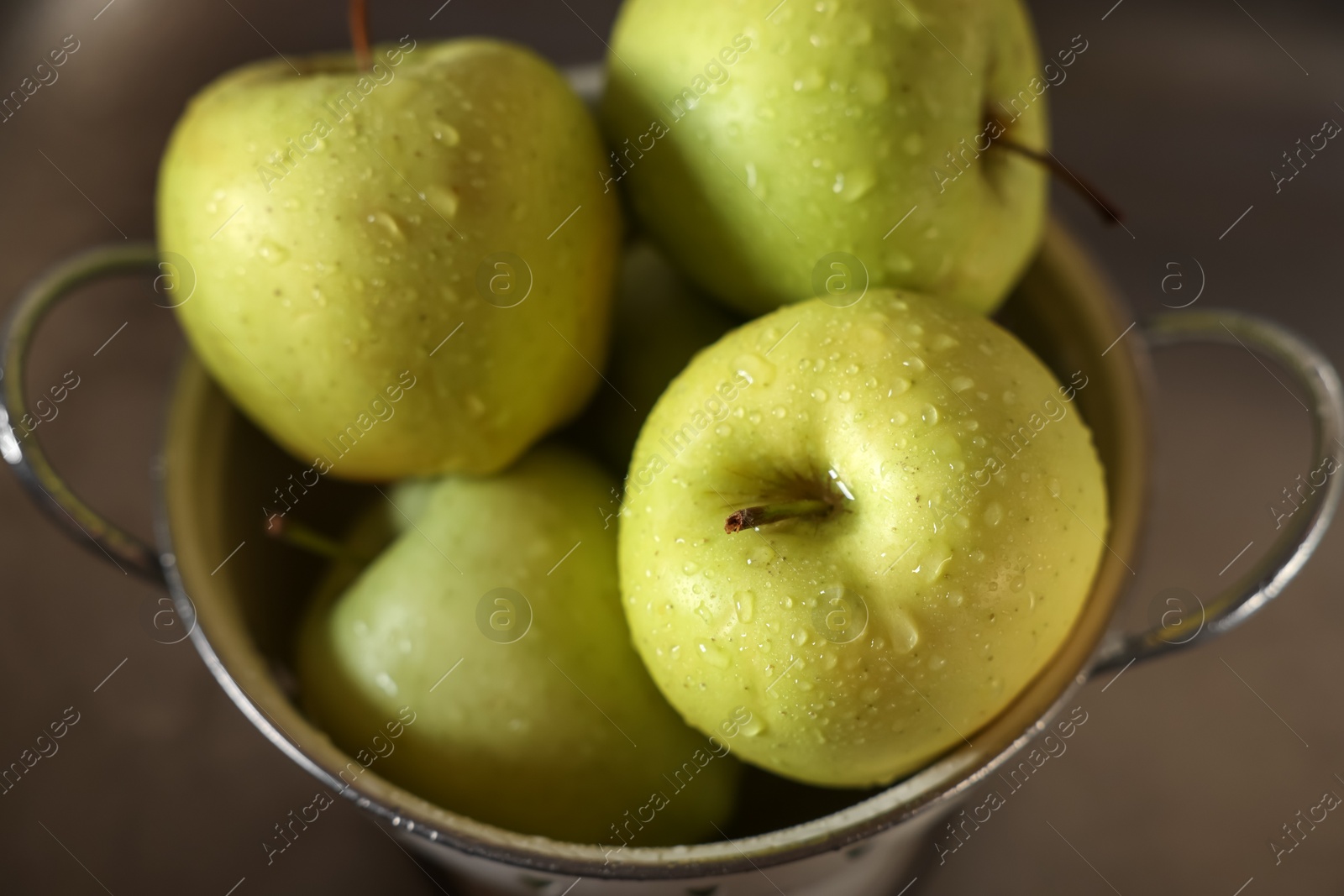 Photo of Fresh wet apples in metal colander inside sink, closeup