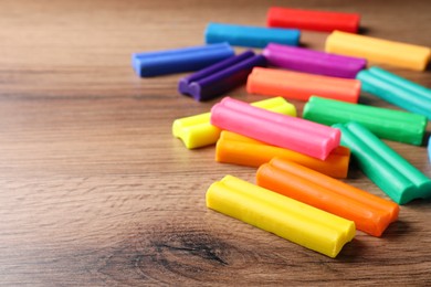 Many different colorful plasticine on wooden table, space for text