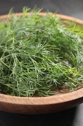 Photo of Bowl of fresh dill on grey table, closeup