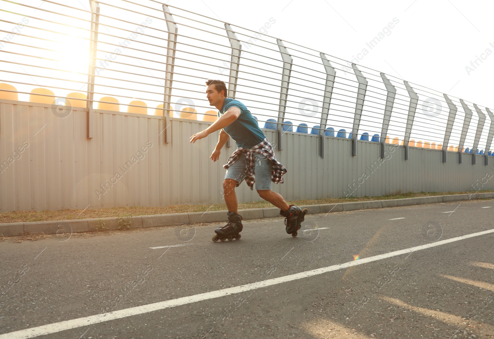 Photo of Handsome young man roller skating outdoors. Recreational activity