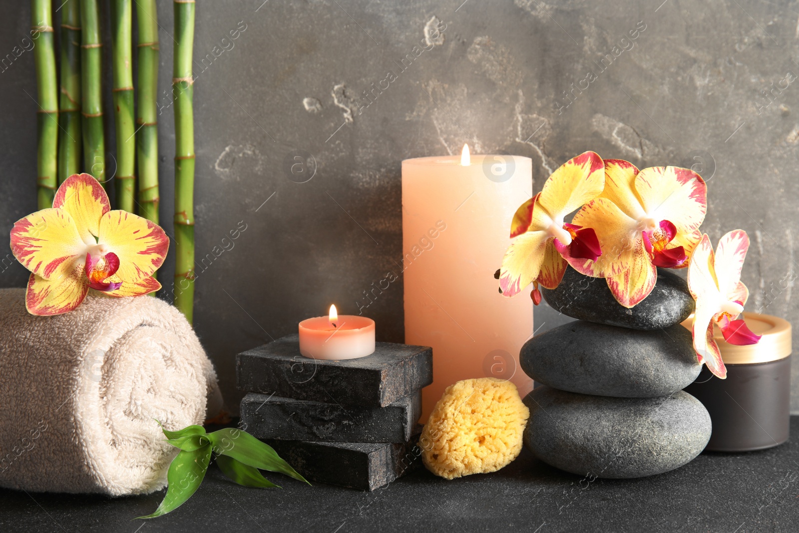 Photo of Beautiful composition with candles and spa stones on table