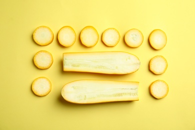 Photo of Fresh ripe cut zucchinis on yellow background, flat lay