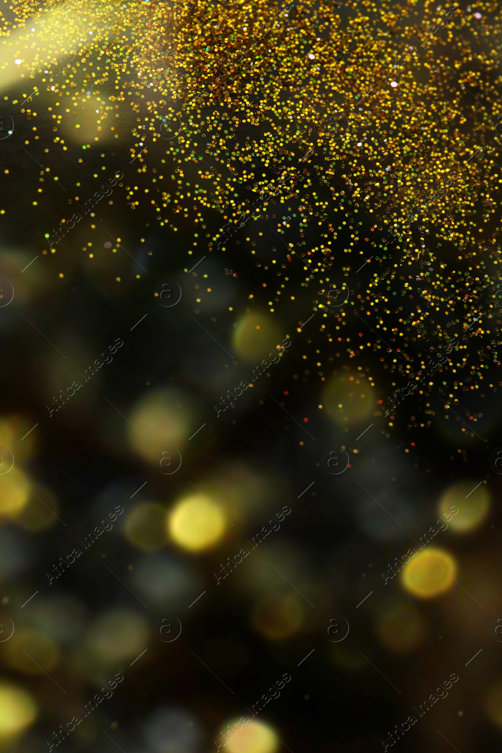 Photo of Shiny golden glitter on blurred background with bokeh effect. Space for text