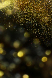 Shiny golden glitter on blurred background with bokeh effect. Space for text