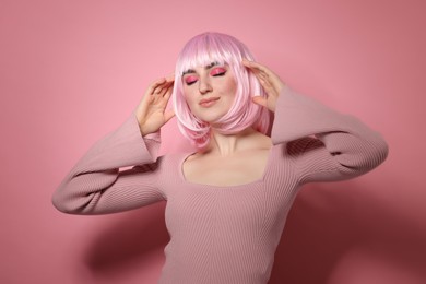 Photo of Beautiful woman with bright makeup and fake freckles on pink background