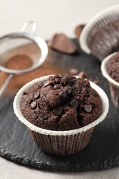 Photo of Delicious chocolate muffins on light table, closeup