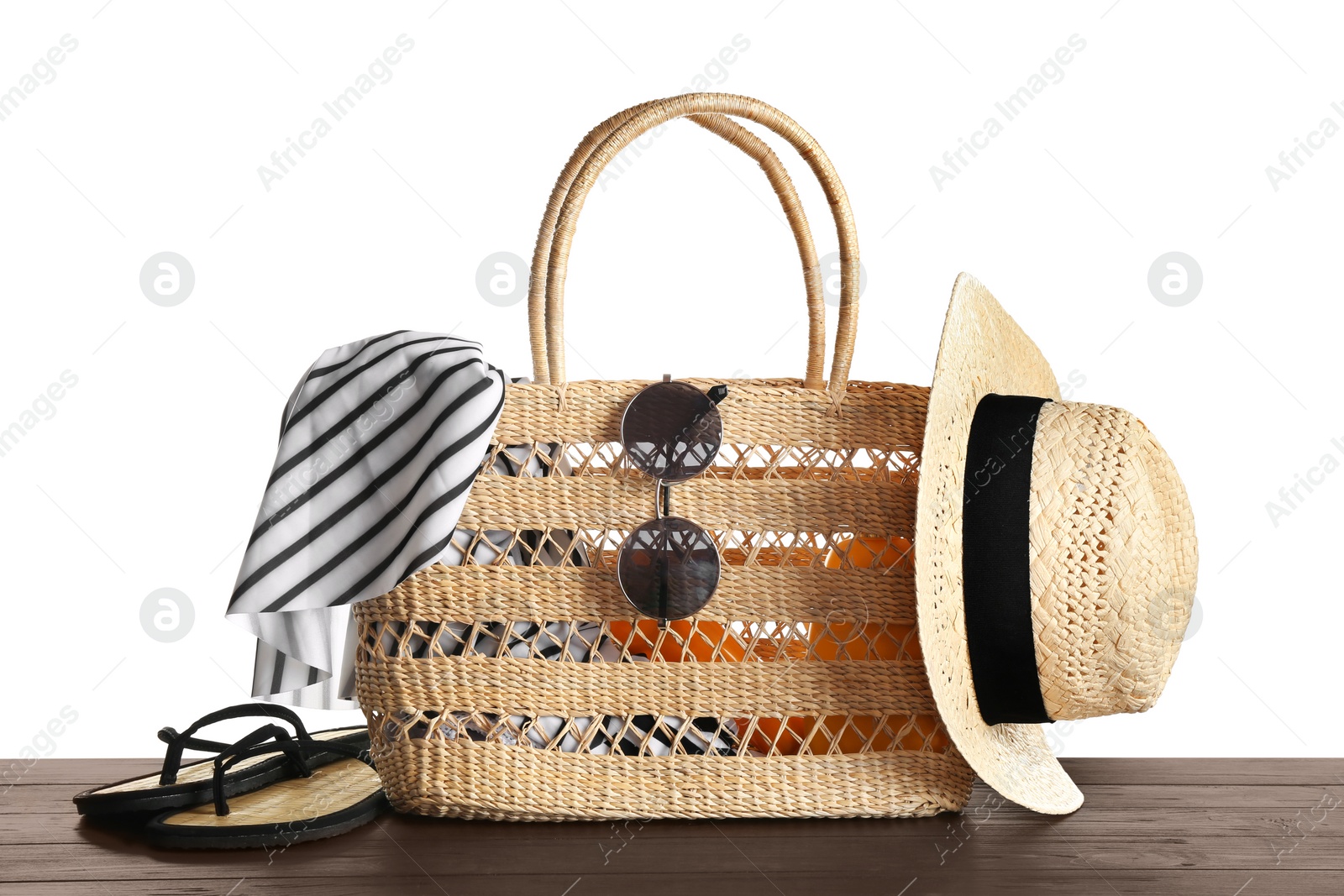 Photo of Set of beach accessories on wooden table, white background