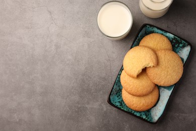 Photo of Delicious Danish butter cookies and milk on grey table, flat lay. Space for text
