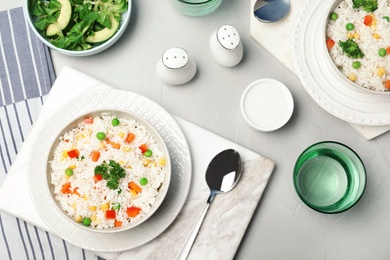 Photo of Boiled rice with vegetables served on table, flat lay