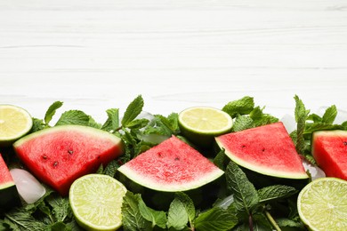 Photo of Tasty sliced watermelon, limes, mint and ice on white wooden table, flat lay. Space for text