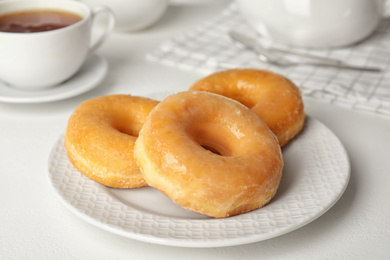 Photo of Sweet delicious glazed donuts on white table