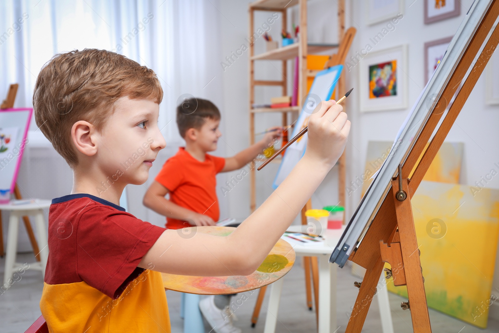 Photo of Cute little child painting during lesson in room