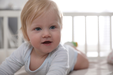 Adorable little baby lying in comfortable crib