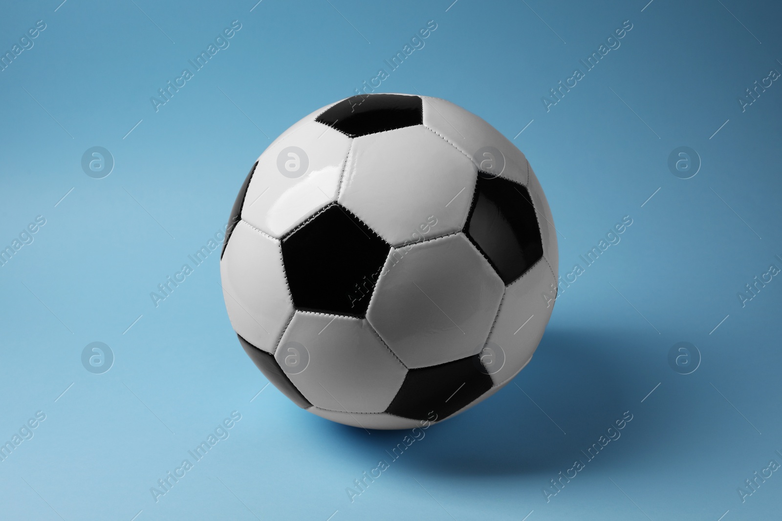 Photo of One soccer ball on light blue background. Sports equipment