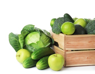 Photo of Wooden crate, fresh green fruits and vegetables on white background