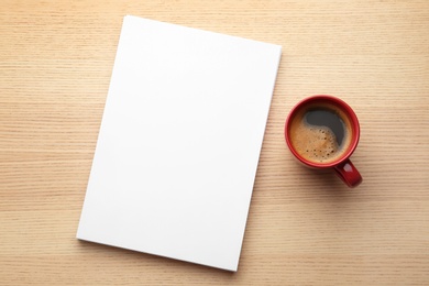 Photo of Blank paper sheets for brochure and cup of coffee on wooden background, flat lay. Mock up