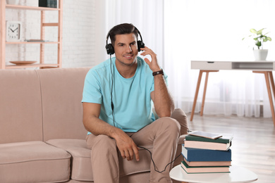 Man listening to audiobook on sofa at home