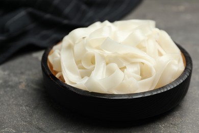 Photo of Tasty cooked rice noodles on grey table, closeup