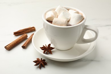 Photo of Tasty hot chocolate with marshmallows and spices on white marble table, closeup