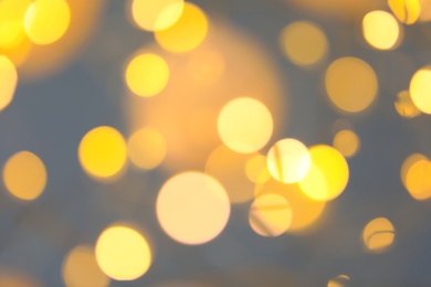 Photo of Blurred view of gold lights on dark background. Bokeh effect
