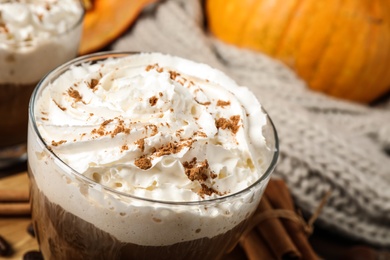 Photo of Glass with tasty pumpkin spice latte on table, closeup