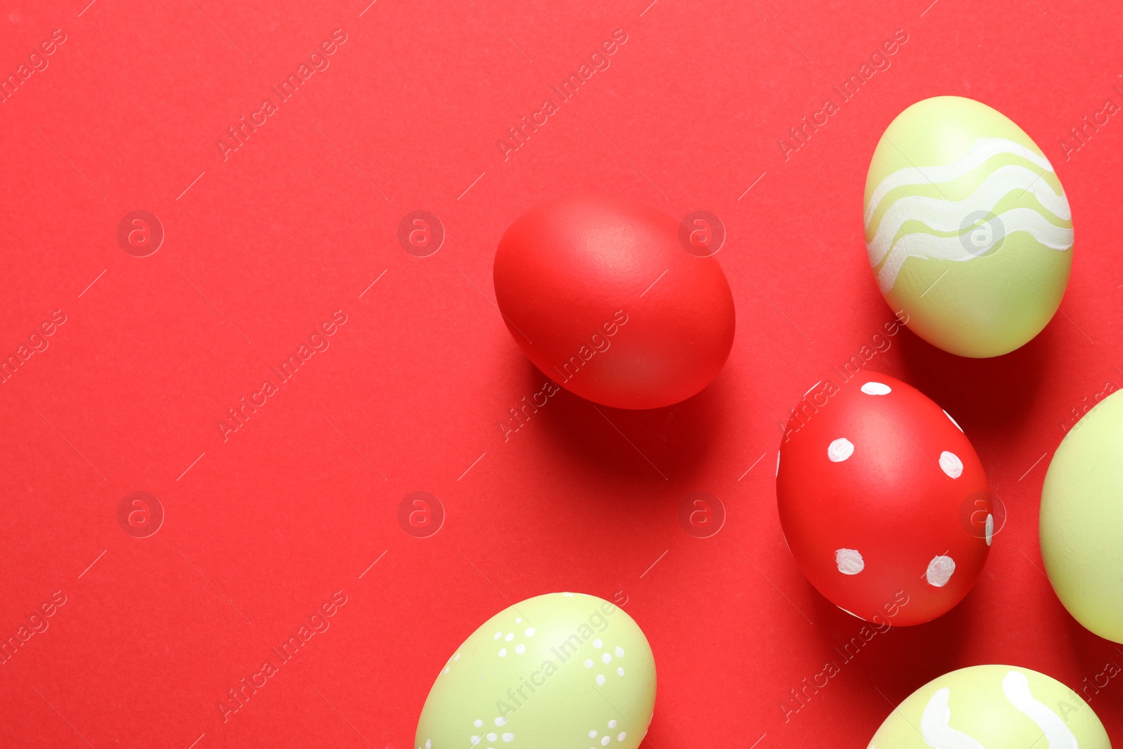 Photo of Flat lay composition with painted Easter eggs on color background, space for text