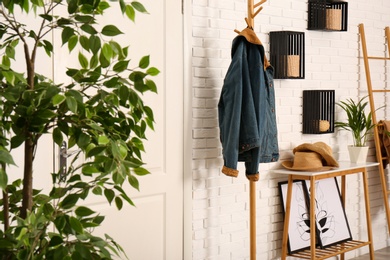 Photo of Stylish hallway interior with hanger stand and table